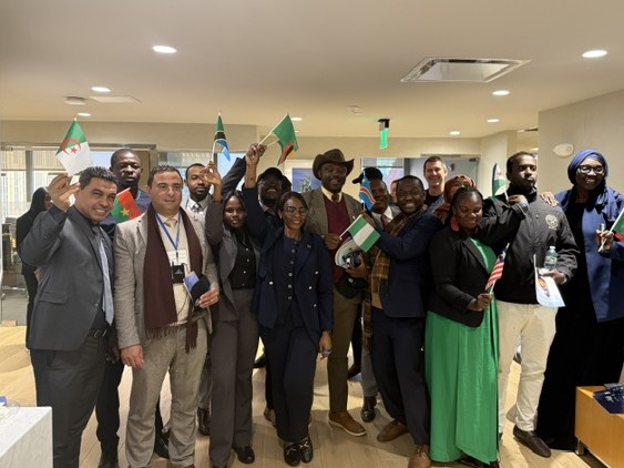 International delegation holding their national flags at a WorldBoston welcome